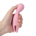 Mão apertando a cabeça de silicone macio do vibrador Nymph Svakom rosa